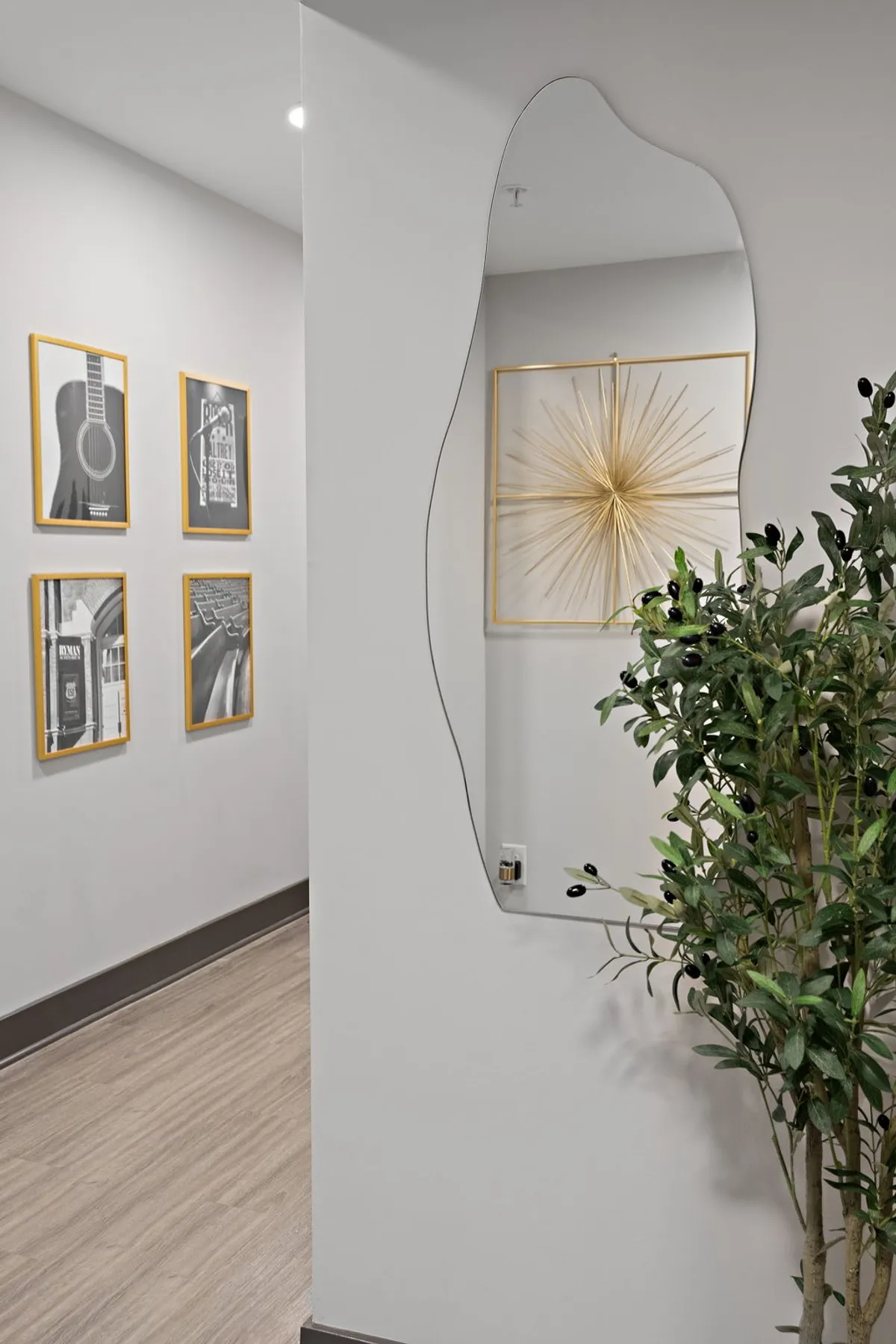 A welcoming interior lounge area featuring a decorative mirror, eye-catching wall art, and an indoor plant. The space is arranged for casual social gatherings and moments of relaxation, with comfortable seating and tasteful decor creating a calm atmosphere.