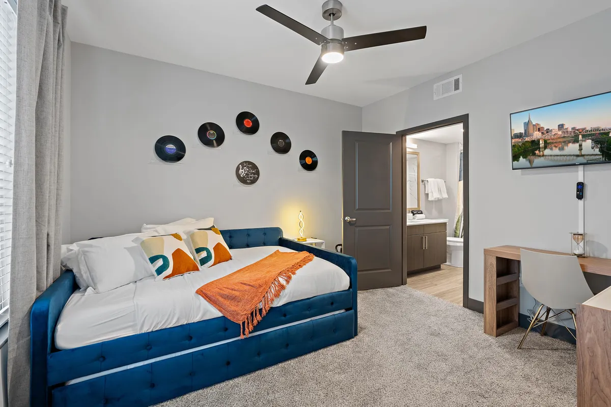 A cozy nook with a daybed, creative wall decor featuring vinyl records, and a practical desk area. The space is perfect for reading, working, or relaxing in comfort.